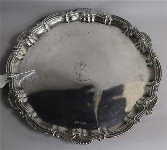 A silver salver with scroll and shell edge on three claw and ball feet, monogrammed, 37.5cm S